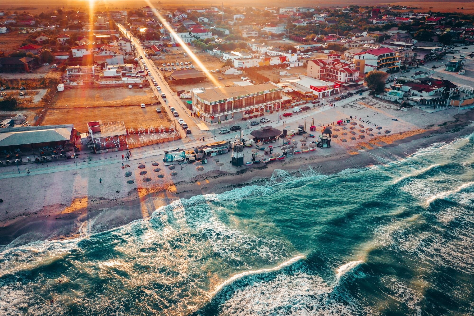 A beach with a road and buildings.
