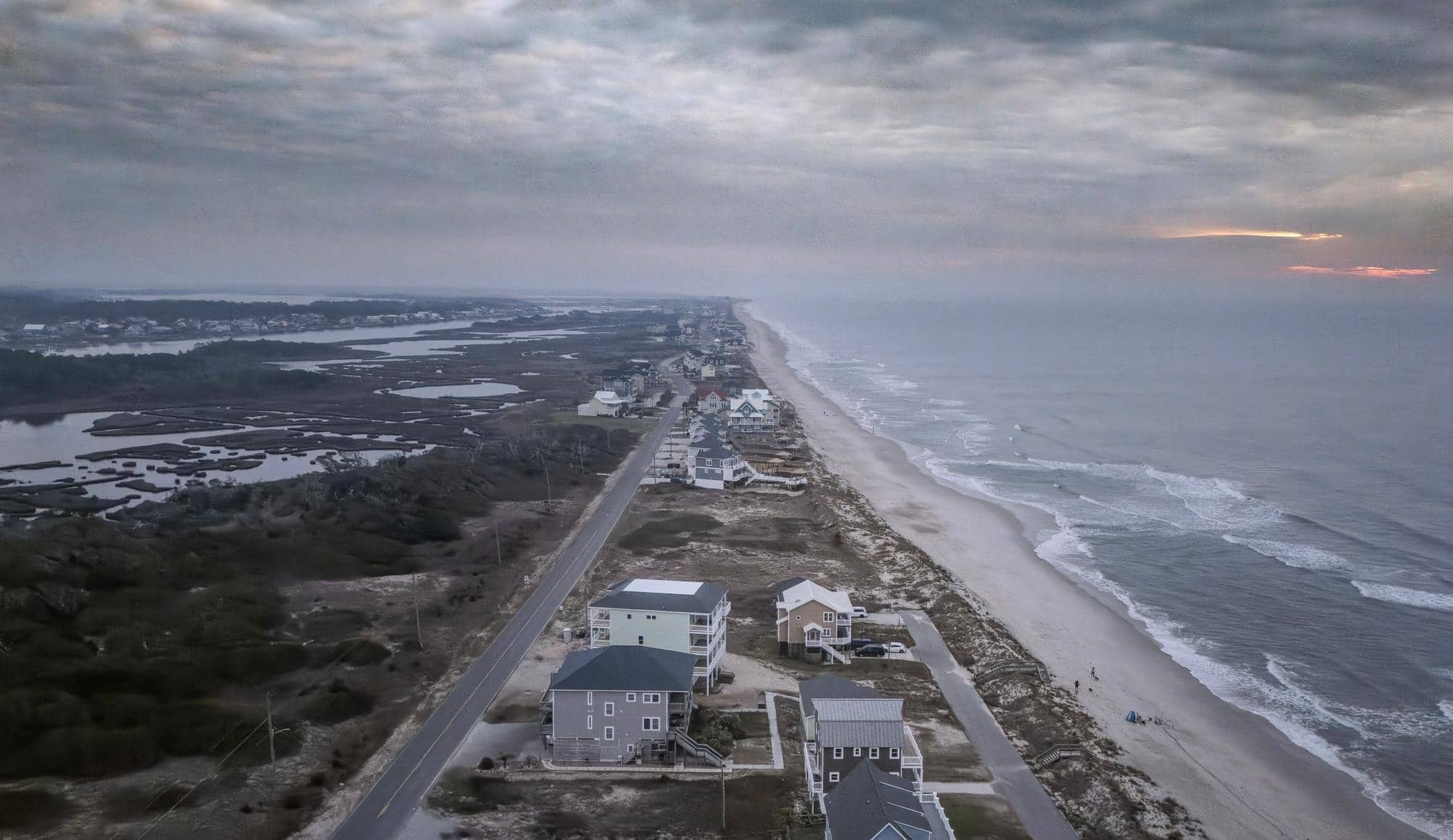 A beach with buildings and water.